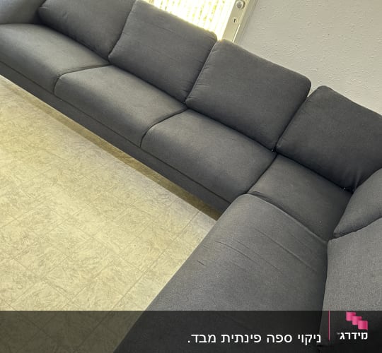 ספה אפורה נקייה ליד חלון מואר